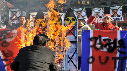 South Korean conservative activists burn anti-North Korean placards during a protest denouncing North Korea's rocket launch, in Seoul on December 12, 2012.